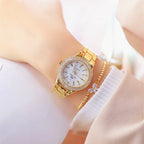 Gold tone watch with crystal bezel and link bracelet on wrist