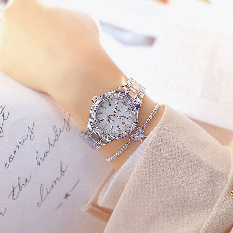 Gold tone watch with crystal bezel and link bracelet on wrist, view 2